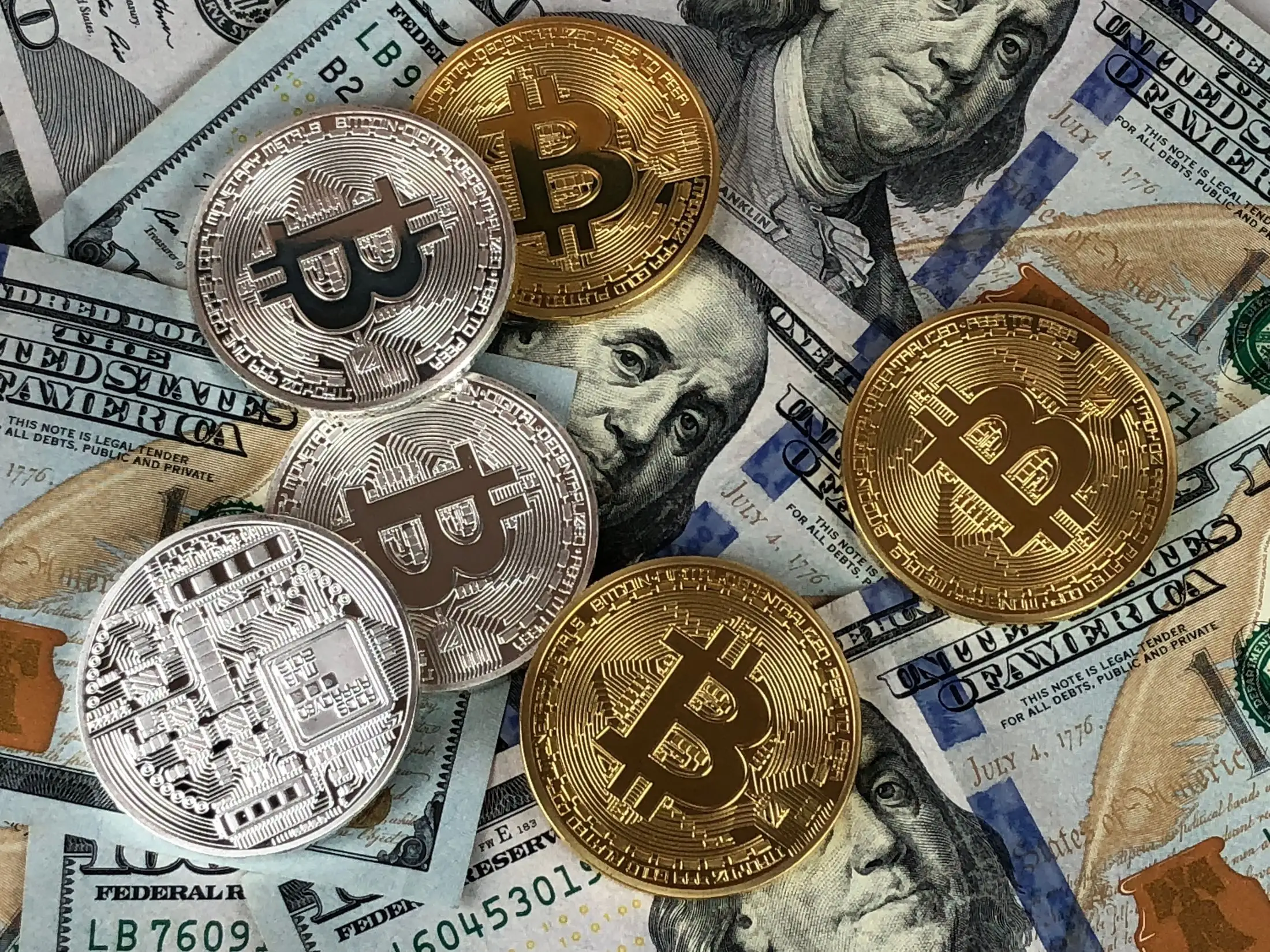 عملات بيتكوين ذهبية وفضية فوق أوراق الدولار الأمريكي