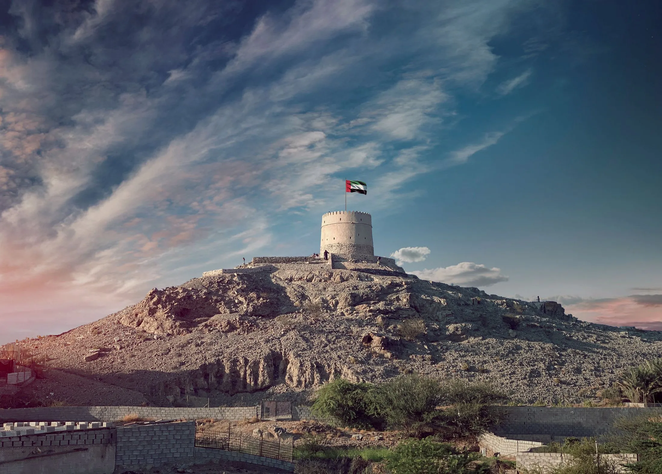 قلعة على تلة يرفرف فوقها علم الإمارات في رأس الخيمة